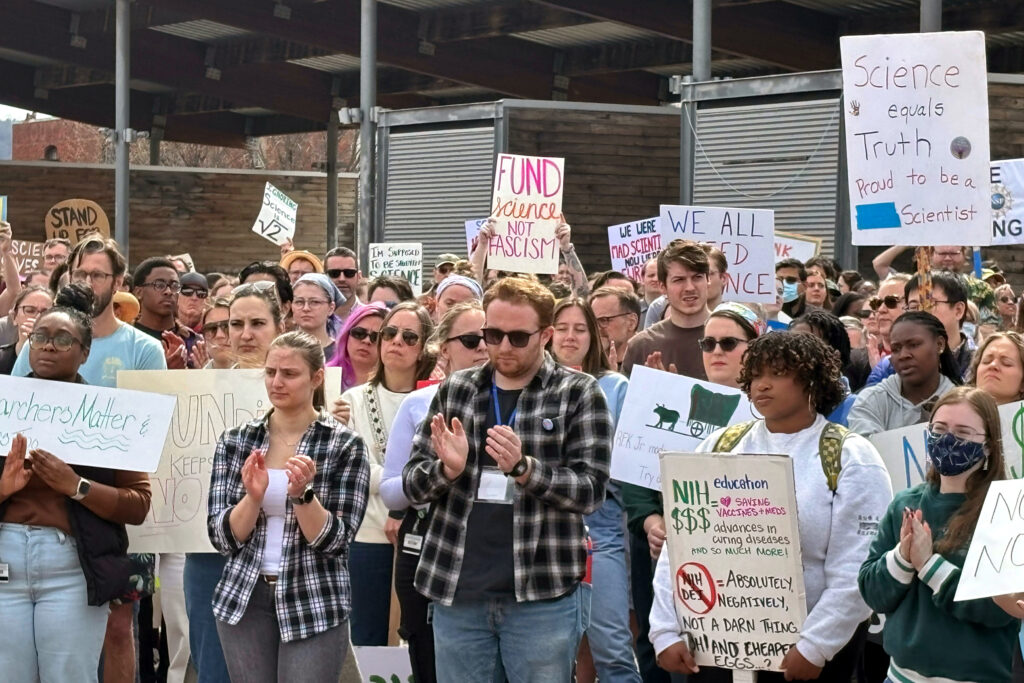PhD student Joshua Lewis addresses the crowd in Birmingham’s Railroad Park. Lewis had a postdoctoral fellowship offer rescinded due to funding concerns after Trump budget cuts. Credit: Dennis Pillion/Inside Climate News