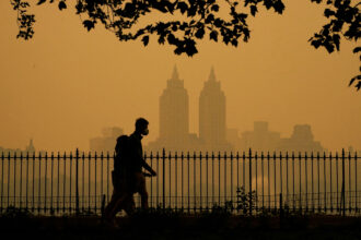 People walk through New York City’s Central Park as smoke from wildfires in Canada cause unhealthy air quality on June 7, 2023. Credit: Timothy A. Clary/AFP via Getty Images