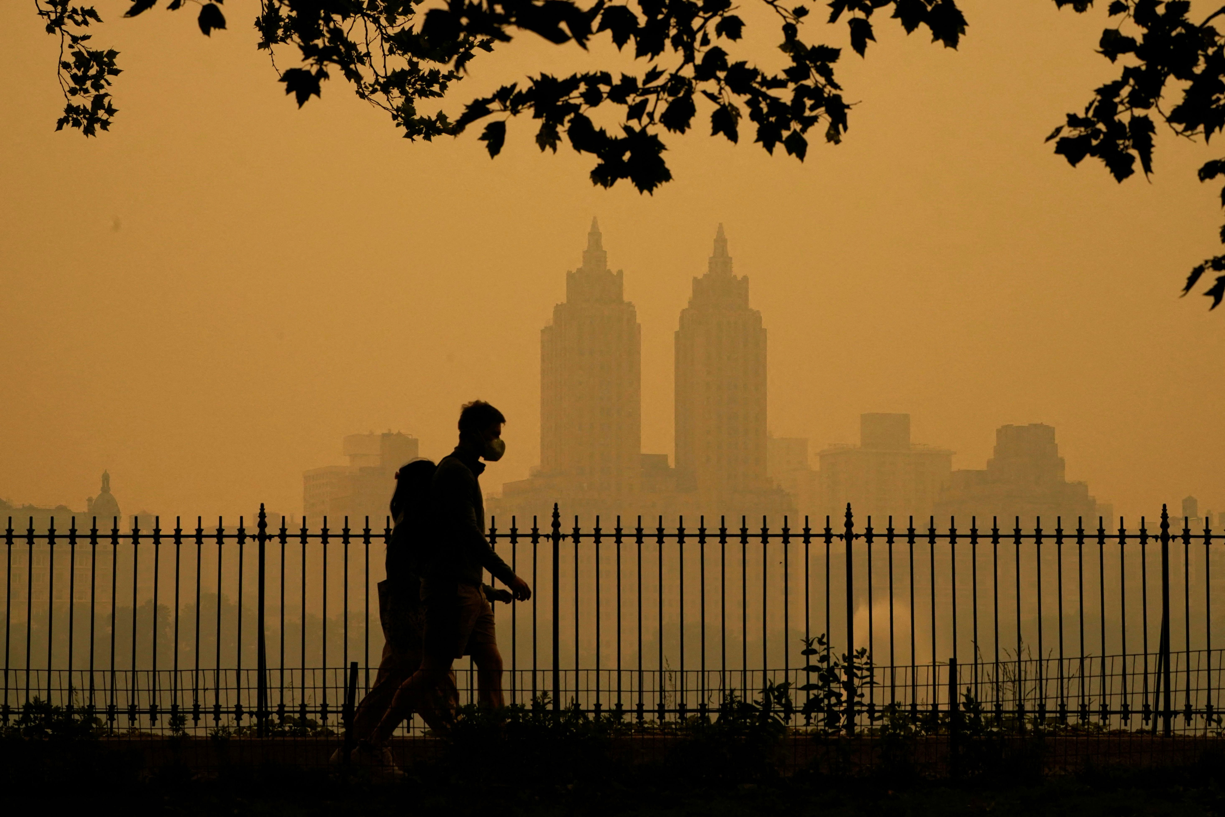 People walk through New York City’s Central Park as smoke from wildfires in Canada cause unhealthy air quality on June 7, 2023. Credit: Timothy A. Clary/AFP via Getty Images