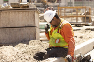 A worker adjusts his helmet on a construction site under the sun in Los Angeles as southern California faces a heatwave on July 3, 2024. Credit: Etienne Laurent/AFP via Getty Images