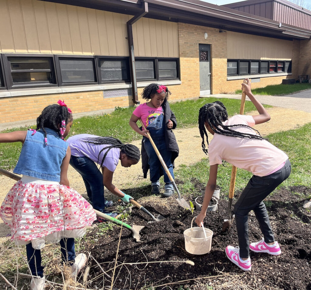 A group of third grade students tend to the garden outside of Mendota Elementary School on April 14 in Madison, Wis. Credit: Erica Krug/Rooted