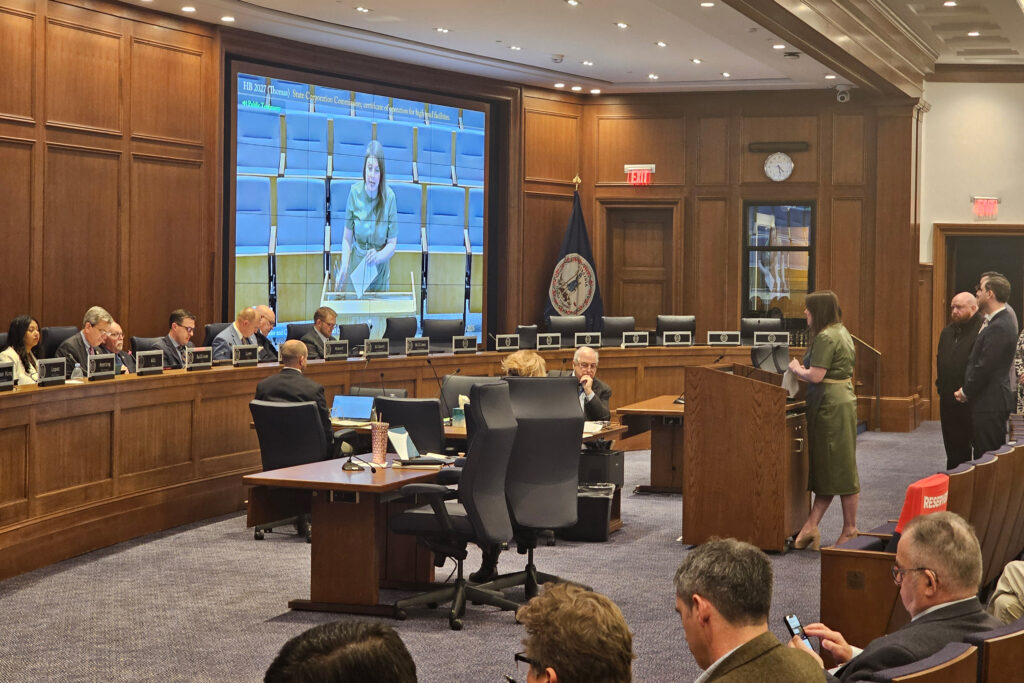 A representative for the Data Center Coalition speaks in opposition to a bill on data centers with Virginia Del. Josh Thomas (D-Prince William) and labor union representatives behind her. Credit: Charles Paullin/Inside Climate News