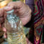 Diane Wilson holds a bottle with PVC plastic powder, a type of microplastic, collected in the Matagorda Bay system in December 2024. Credit: Dylan Baddour/Inside Climate News