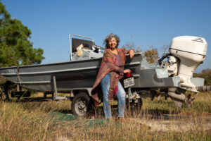 Diane Wilson pictured by her skiff outside her Calhoun County home in December 2024. Credit: Dylan Baddour/Inside Climate News