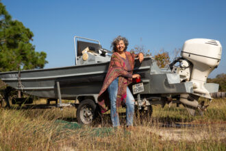 Diane Wilson pictured by her skiff outside her Calhoun County home in December 2024. Credit: Dylan Baddour/Inside Climate News