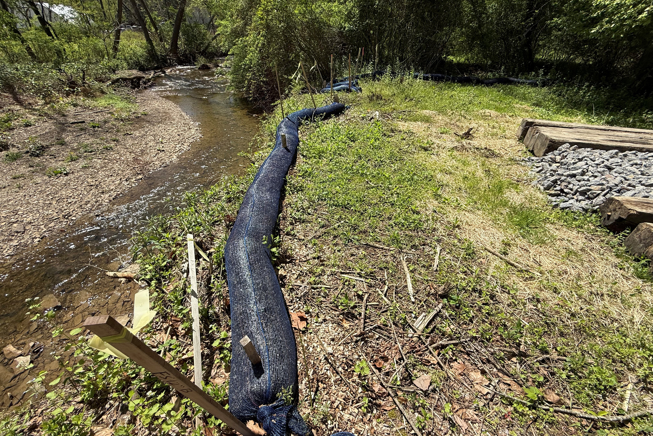 A view of Big Sewickley Creek downstream from PennEnergy’s proposed water withdrawal site shows erosion control (center) and a portion of the project workspace and parking area (gravel and log on right). Credit: Rose Reilly/Big Sewickley Creek Watershed Association