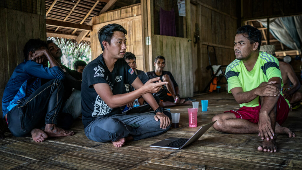 Hafiz Nasarudin of Kuasa, president of KUASA, consults with Mustafa Along about logging companies on Temiar land. 