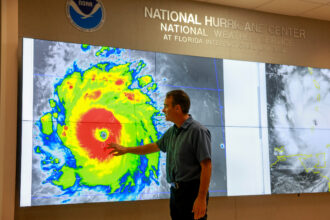John Cangialosi, senior hurricane specialist at NOAA’s National Hurricane Center, inspects a satellite image of Hurricane Beryl on July 1, 2024, in Miami. Credit: Joe Raedle/Getty Images