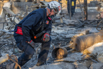 A member of the FEMA Urban Search and Rescue team searches the ruins of a home destroyed by the Eaton Fire on Jan. 11 in Altadena, Calif. Credit: David McNew/Getty Images