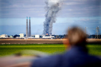 A bystander watches a fire burn at the Vistra Corp. battery storage plant on Jan. 17 in Moss Landing, Calif. Credit: Doug Duran/Digital First Media/East Bay Times via Getty Images