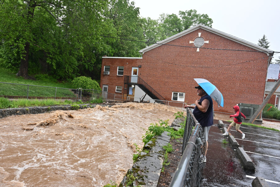 Chaz Netzer and his son Jaxson, 8, watch the deluge of water gathering up at the Calvary Christian Academy as flash flood warnings are in effect on May 13 in Cresaptown, M.D. Credit: Ricky Carioti/The Washington Post via Getty Images