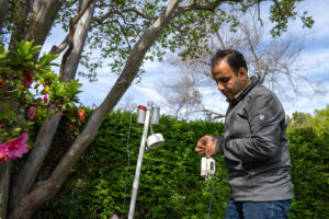 Parham Azimi, a Harvard University researcher, checks an outdoor air monitor which has been collecting samples for the last week outside Nicole Bryne’s house on April 1 in Pasadena, Calif. Credit: Nina Dietz/Inside Climate News