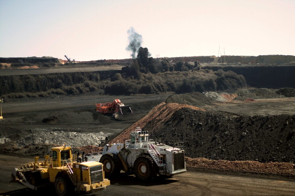 Heavy vehicles stop moving as a timed detonation brings down a wide coal face at the Buckskin Coal Mine, in Gillette, Wyoming. Credit: Robert Nickelsberg via Getty Images