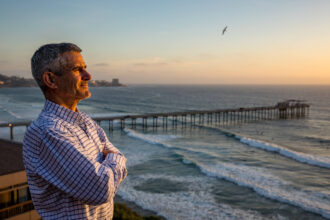 Mark Ellis, a former Sempra Corp. executive who has made an unusual shift and become a consumer advocate, poses on a bluff overlooking Scripps Pier at U.C. San Diego’s Scripps Institution of Oceanography, which is near his home. Credit: David Poller/Inside Climate News
