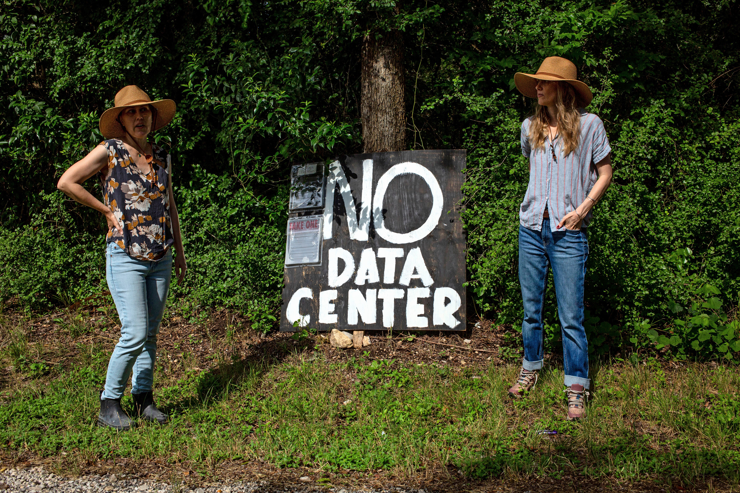 Sisters Abigail and Jennifer Lindsey stand on their rural property on May 27 outside New Braunfels, Texas, where they posted a sign in opposition to a large data center and power plant planned across the street. Credit: Dylan Baddour/Inside Climate News