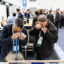 Participants at the Association for Mineral Exploration conference in Vancouver in January examine core samples through magnifying devices. The yearly conference is known as a gathering place for companies with prospects in Alaska. Credit: Jesse Winter for Northern Journal and Inside Climate News