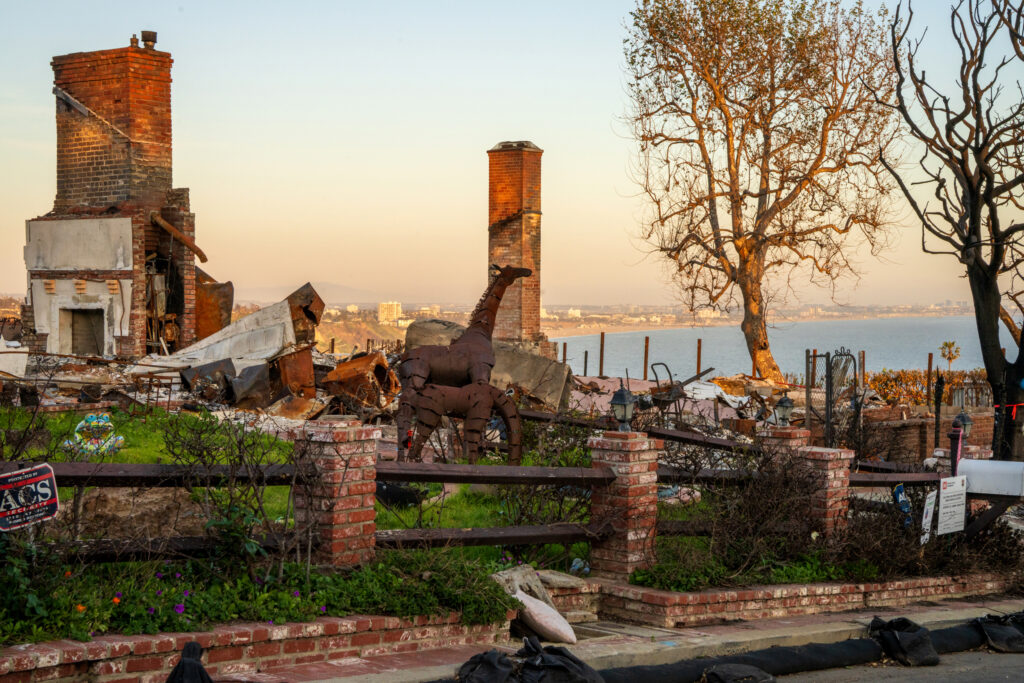 Golden hour lights up the remnants of a neighbor’s burned sculpture garden next door to 262 Quadro Vecchio Drive.