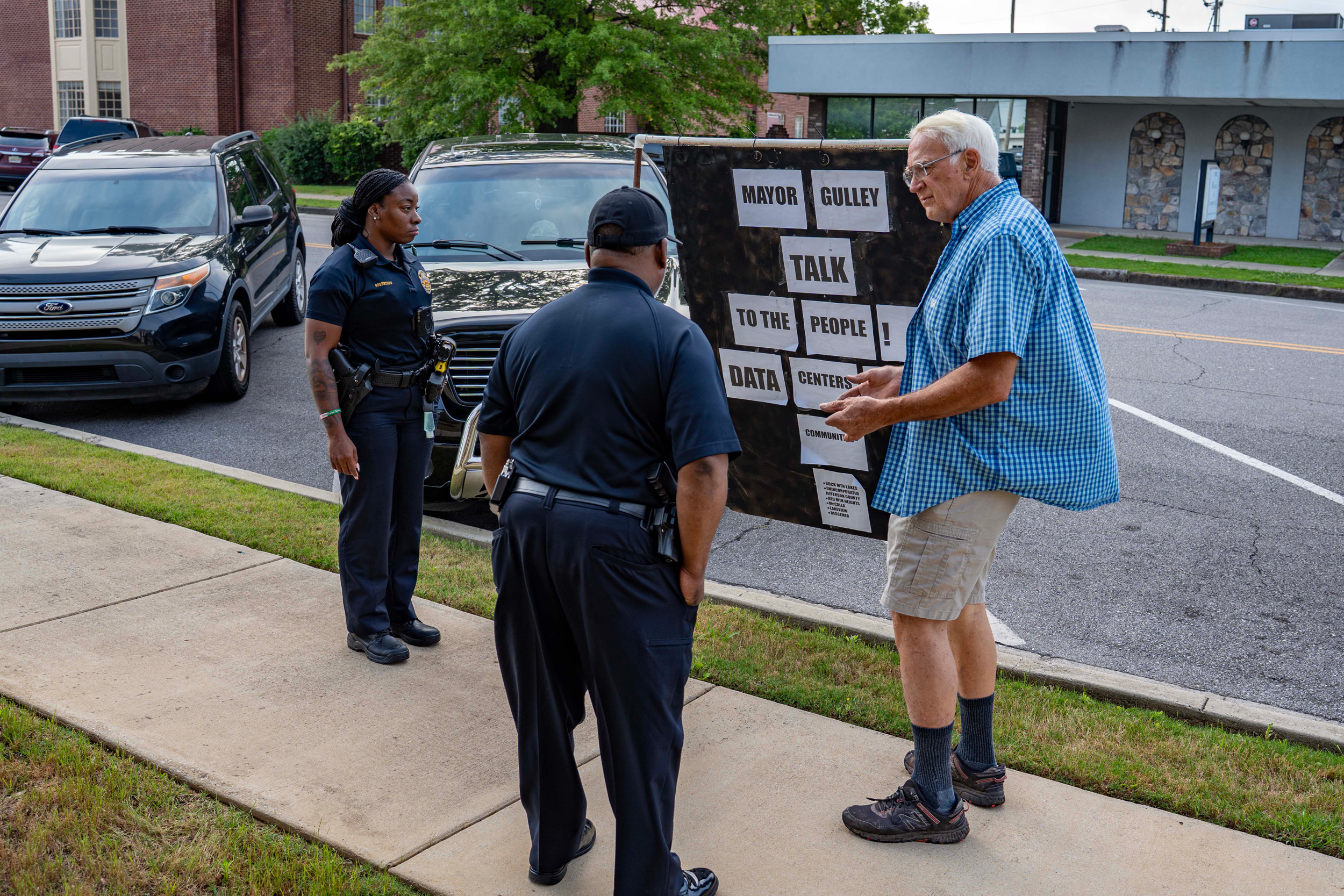 On Monday, the day before the meeting, Bessemer police confront Marshall Killingsworth, who planned to stand with his sign outside City Hall until the mayor agreed to meet with him. He was forced to remove the sign. Credit: Lee Hedgepeth/Inside Climate News