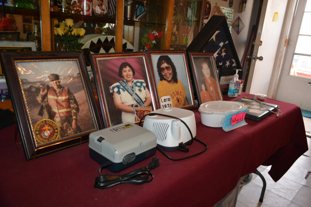 Photos of a young Carol Parrish and her family are seen next to her asthma nebulizer in her home on the Navajo Nation on May 29. Credit: Wyatt Myskow/Inside Climate News