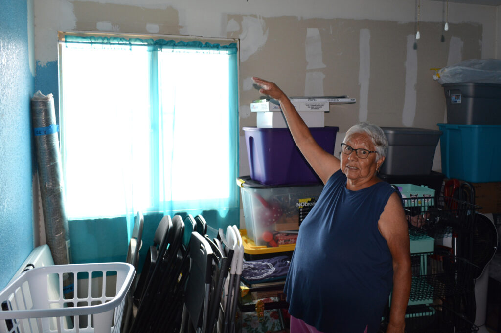 Susan Blackhair points to where her roof has been patched thanks to assistance from the nonprofit Red Feather. Credit: Wyatt Myskow/Inside Climate News