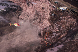 A helicopter overflies the area of a collapsed dam as rescue workers search for victims near the town of Brumadinho in southeastern Brazil on Jan. 25, 2019. Credit: Douglas Magno/AFP via Getty Images