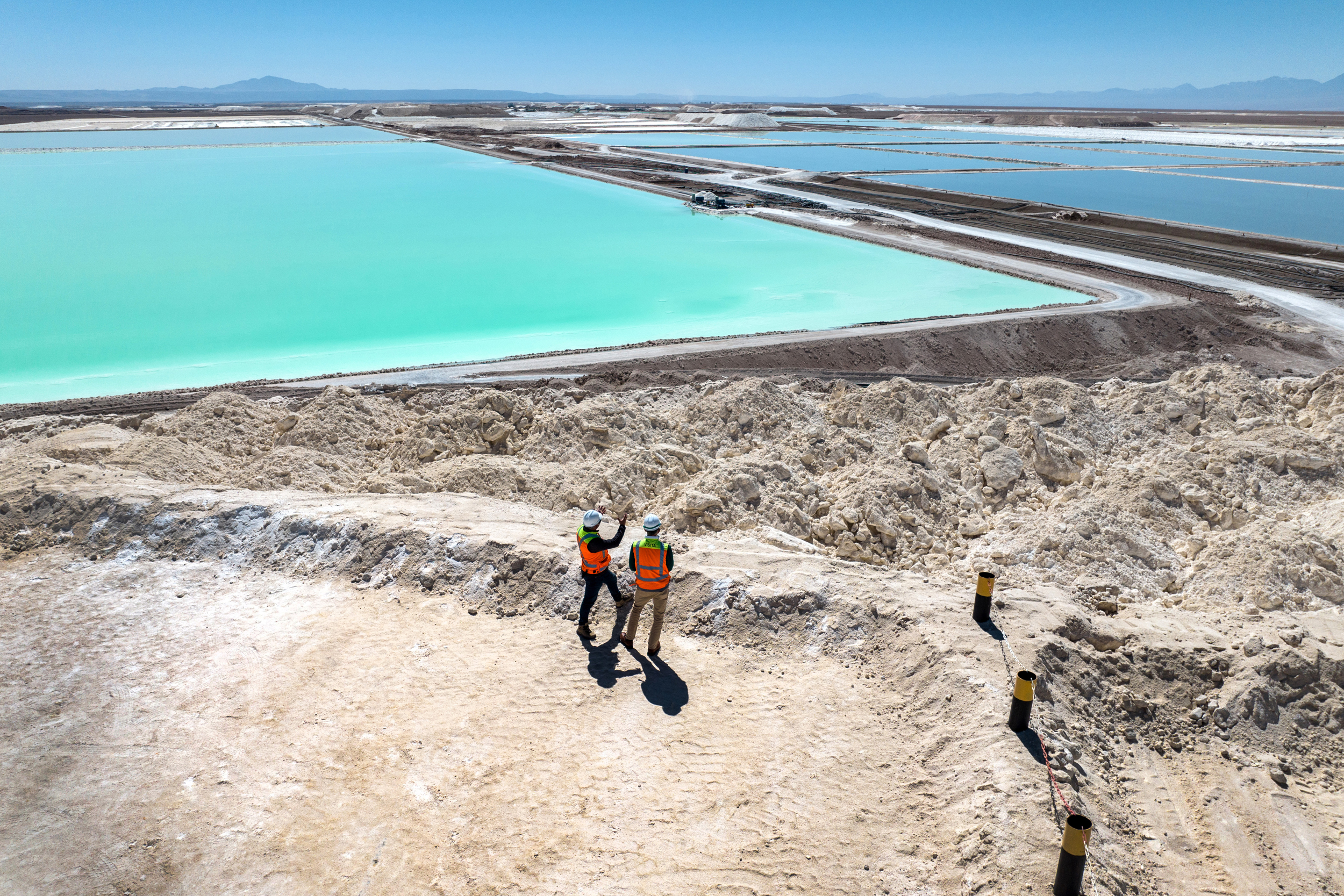 Visitors stand atop a large mound of salt byproduct from lithium production at a mine in the Atacama Desert of Chile. Credit: John Moore/Getty Images