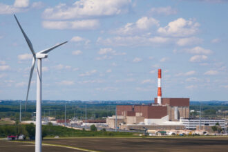 An aerial view of Constellation Energy’s nuclear power plant with a wind power turbine in the foreground near Marseilles, Ill. Credit: Scott Olson/Getty Images