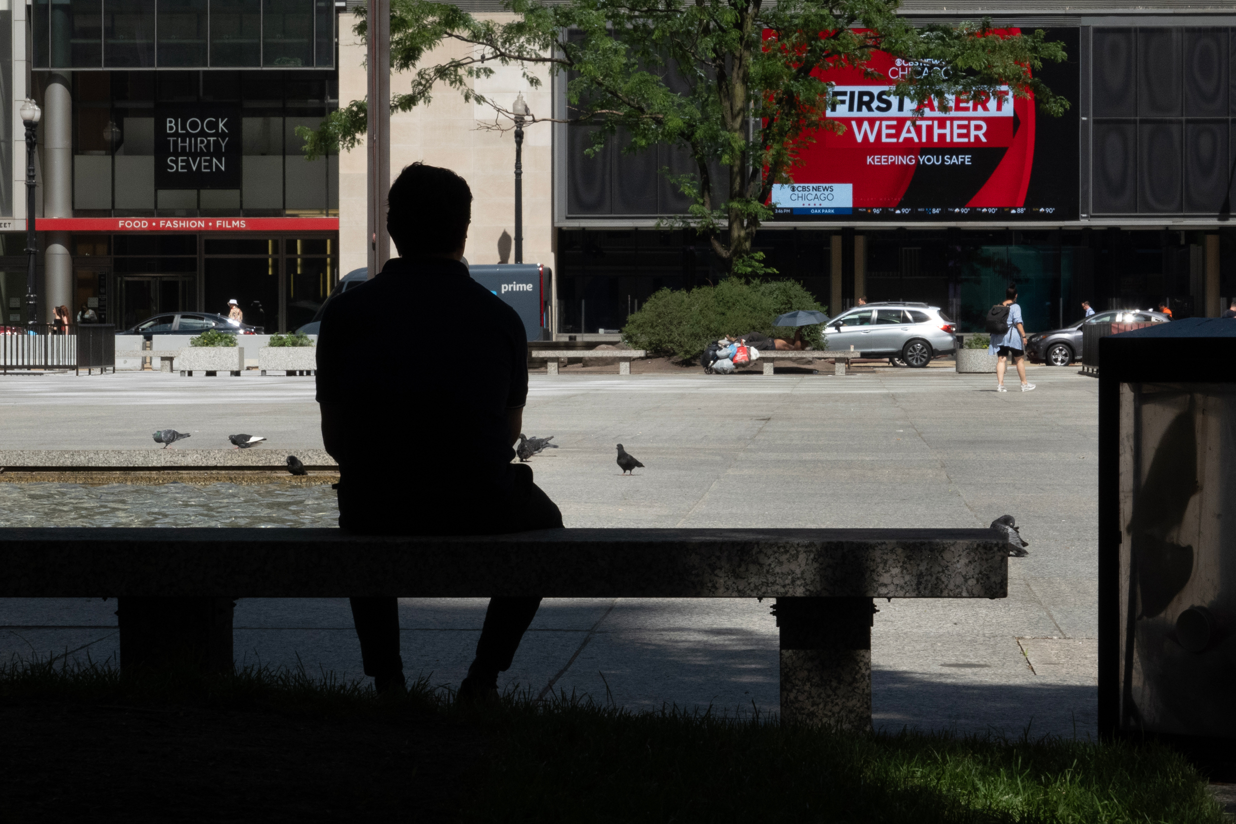 A man cools off in the shade at Daley Plaza as temperatures climbed into the mid-90s on June 23 in Chicago. Credit: Scott Olson/Getty Images