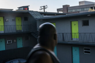 In Vancouver, Washington, Everett Clayton looks at a digital thermometer on a nearby building that reads 116 degrees while walking to his apartment on June 27, 2021. Credit: Nathan Howard/Getty Images