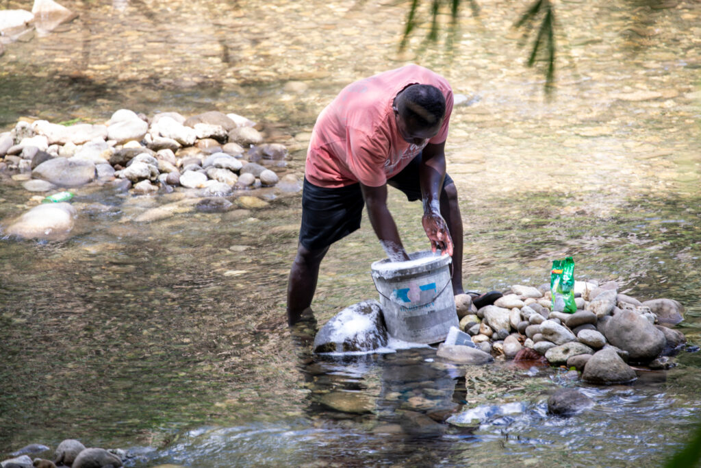 A man washes laundry in a stream in Honiara in the Solomon Islands. Credit: Nathan Eagle/Civil Beat