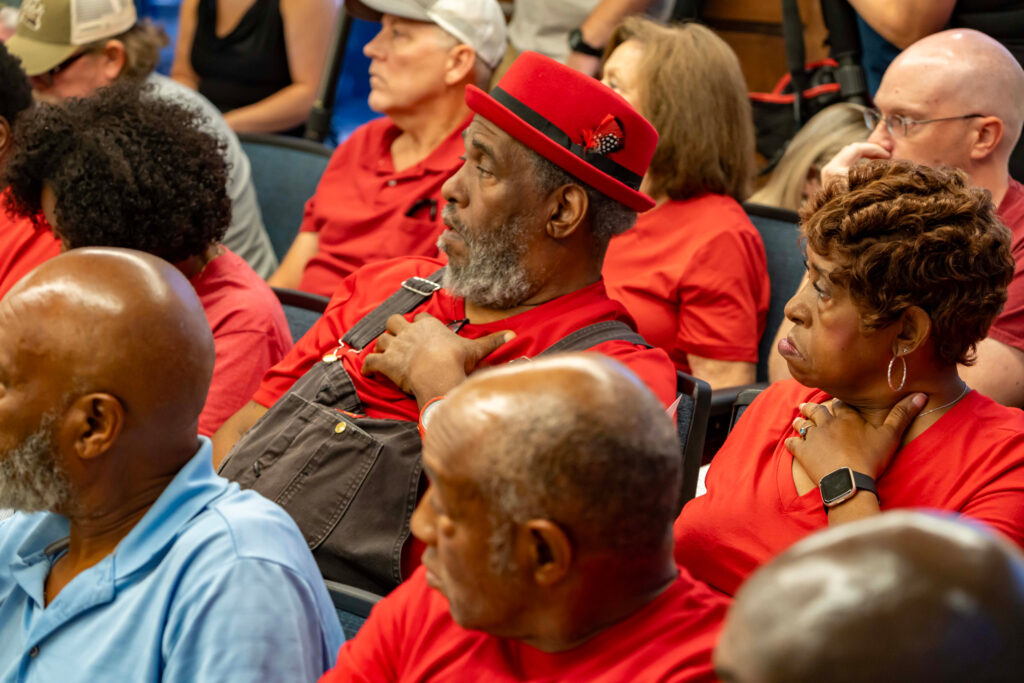 Bessemer residents wear red to show their opposition to the proposed data center during a July meeting. Credit: Lee Hedgepeth/Inside Climate News