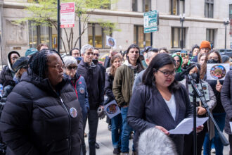 Cheryl Johnson (left), executive director of People for Community Recovery and the daughter of Hazel Johnson, stands next to Chicago Department of Environment Commissioner Angela Tovar, as she speaks at a rally outside of City Hall in April. Credit: Keerti Gopal/Inside Climate News