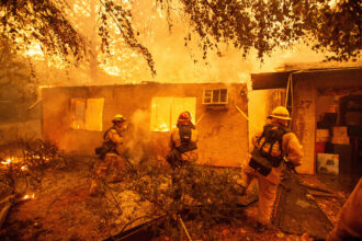 Firefighters battle against a burning apartment complex in Paradise as a late-season wildfire in northern California burns 20,000 acres on Nov. 9, 2018. Credit: Josh Edelson/AFP via Getty Images
