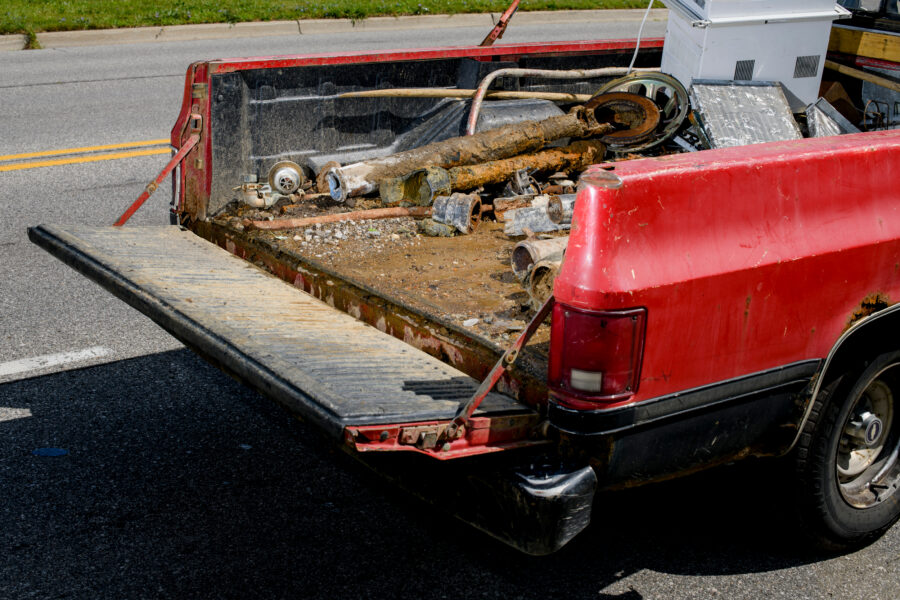 A scrapper collects plumbing fixtures pulled out of the ground by the City of Flint’s lead line replacement crew on Aug. 12, 2021. Credit: Brittany Greeson/The Washington Post via Getty Images