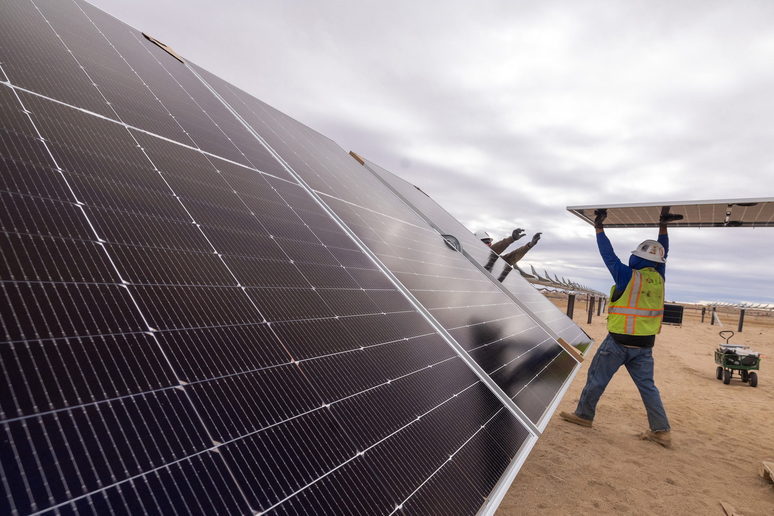 Workers install solar panels for the Los Angeles Department of Water and Power’s Eland Solar and Storage Center in the Mojave Desert of Kern County on Nov. 25, 2024. Credit: Brian van der Brug/Los Angeles Times via Getty Images