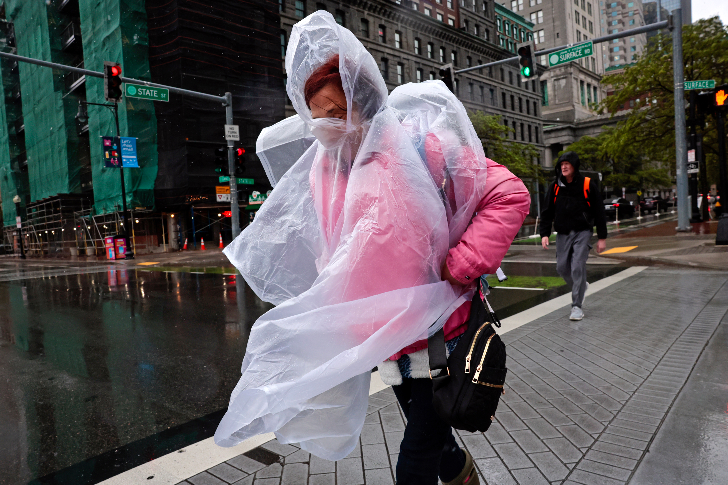 A woman wears a poncho to protect herself from wind-blown rain during a rare spring nor’easter in Boston on May 22. Credit: Craig F. Walker/The Boston Globe via Getty Images