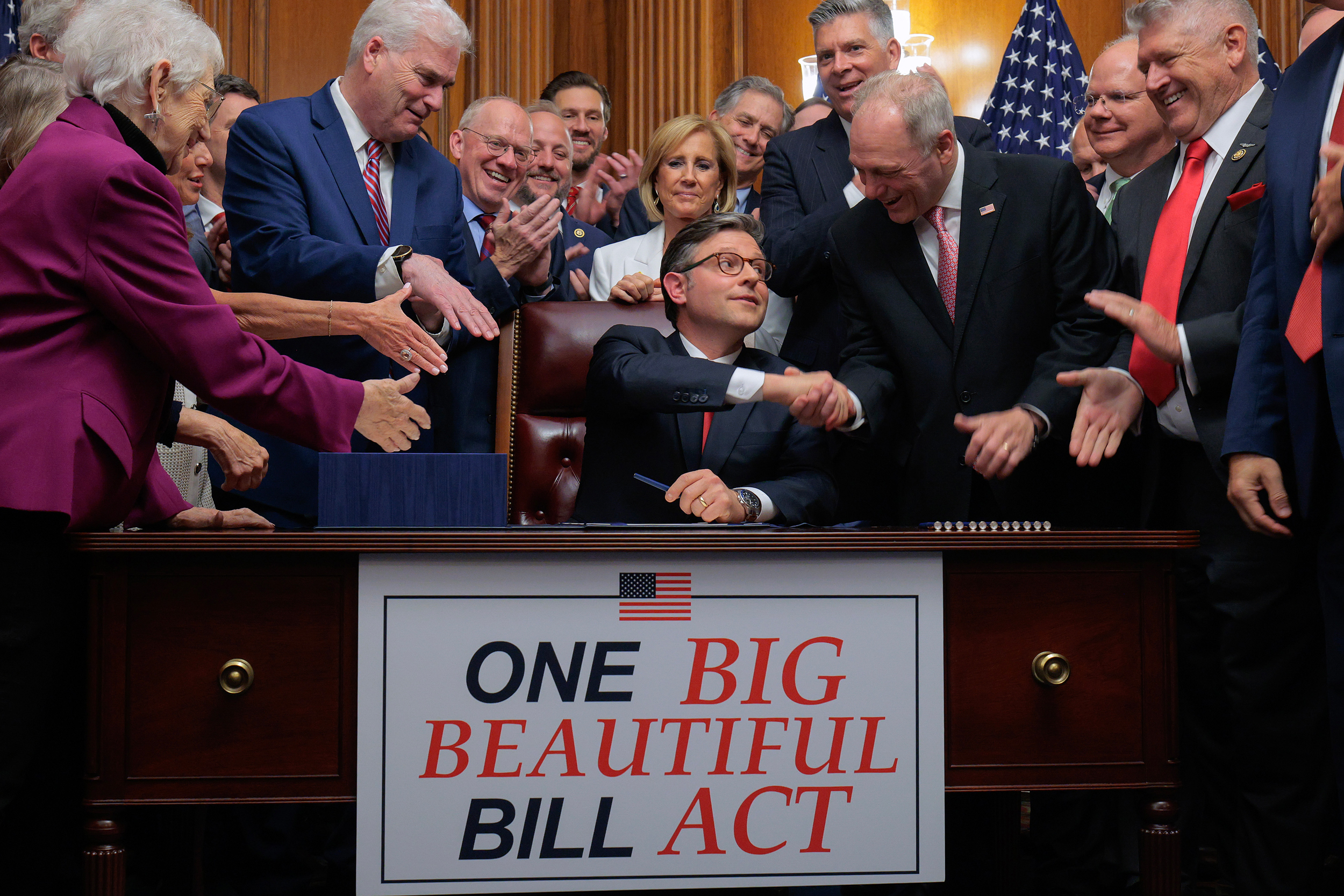 Speaker of the House Mike Johnson (center) is congratulated by his fellow Republicans after signing the One Big Beautiful Bill Act at the U.S. Capitol on Thursday. Credit: Chip Somodevilla/Getty Images