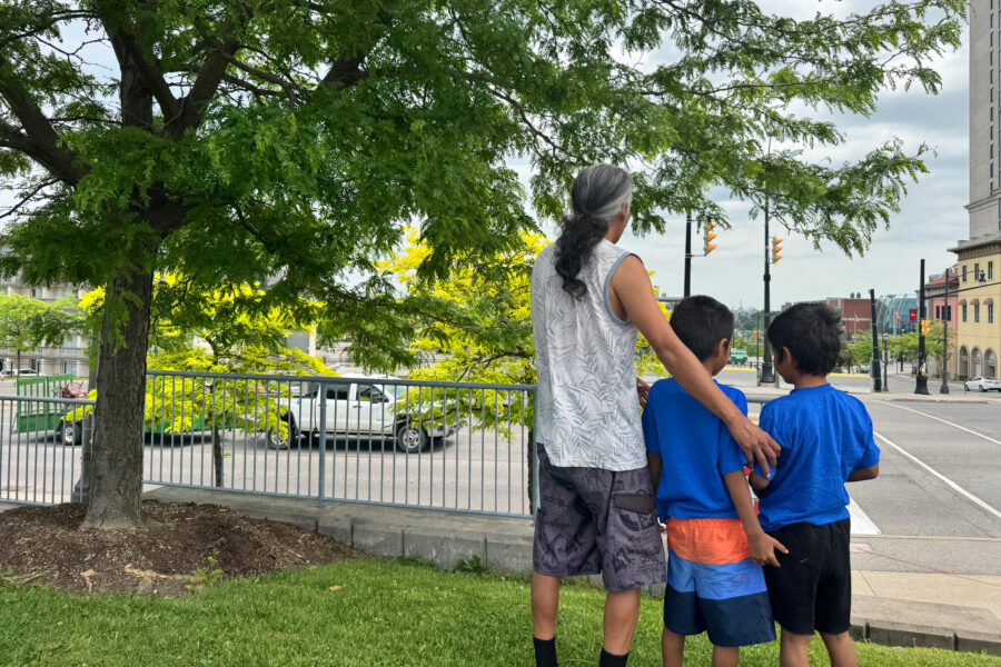 Geoffrey Ross and his two children, ages 5 and 6, stare ahead at the city of Niagara Falls, Ontario, outside a coffee shop on June 5. Wildfires in Manitoba forced them to evacuate. Credit: Angeles Ponpa/Medill News Service