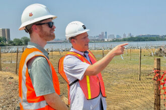 Brad Rogers (right), of the South Baltimore Gateway Partnership, and Andrew Forbes, senior project manager at Greenvest, look at a restored tidal marsh in the heart of South Baltimore. Credit: Aman Azhar/Inside Climate News
