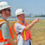 Brad Rogers (right), of the South Baltimore Gateway Partnership, and Andrew Forbes, senior project manager at Greenvest, look at a restored tidal marsh in the heart of South Baltimore. Credit: Aman Azhar/Inside Climate News