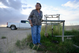 Loretta Johnson stands by a water well on the Navajo Nation in New Mexico. According to an EPA report, the well produces water tainted with arsenic. Credit: Jerry Redfern/Capital & Main