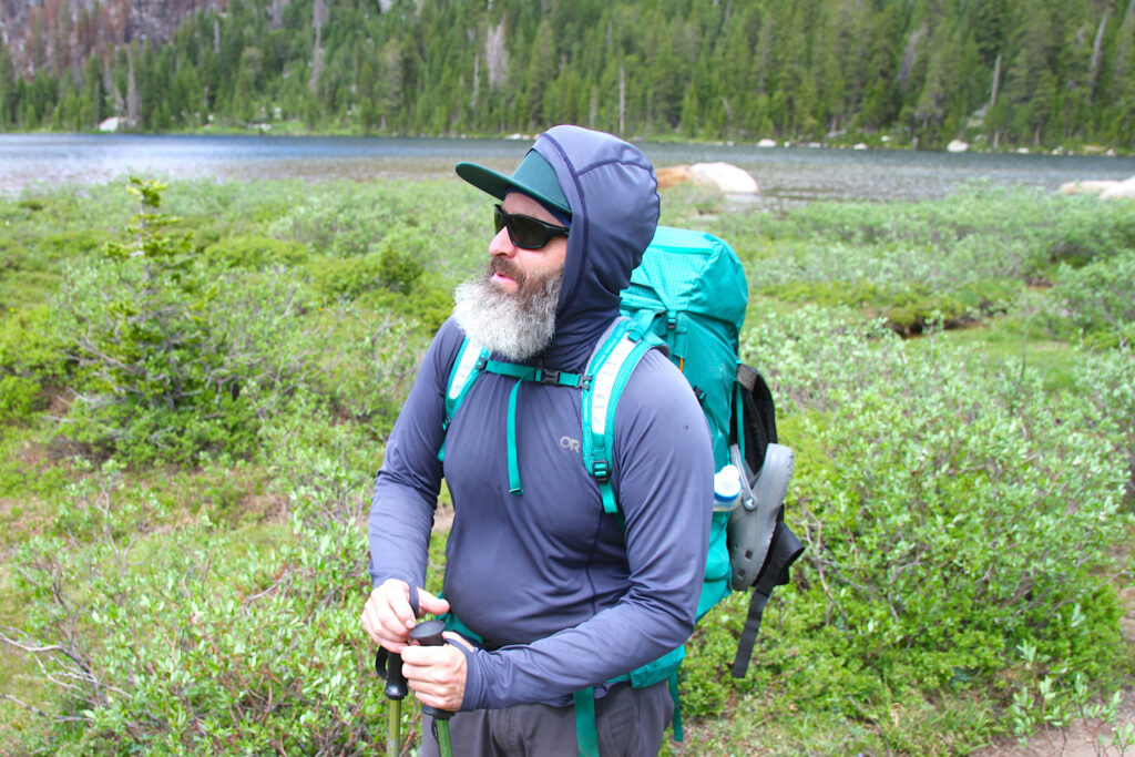 Carl Meinecke, a Roaring Fork Valley, Colorado arborist, reflects on human use-related water quality issues suspected to be plaguing Lonesome Lake, in the background. Credit: Mike Koshmrl/WyoFile