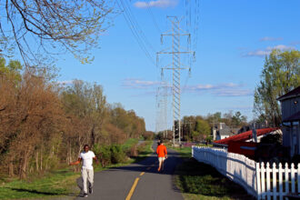 Transmission lines stand above a multi-use path adjacent to homes in Loudoun County, Va. Credit: Charles Paullin/Inside Climate News