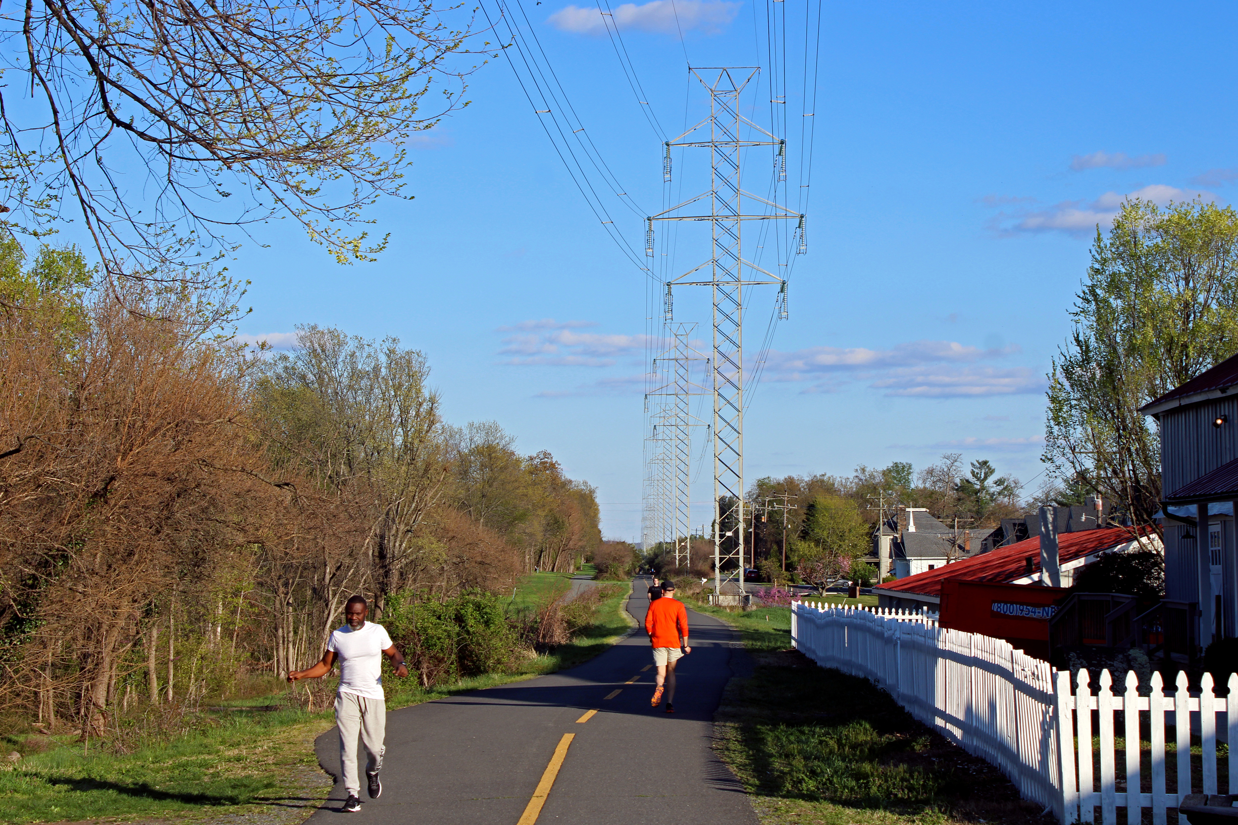 Transmission lines stand above a multi-use path adjacent to homes in Loudoun County, Va. Credit: Charles Paullin/Inside Climate News