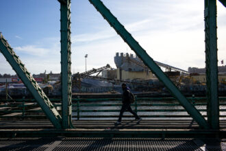 A pedestrian crosses the Grand Street Bridge over the heavily polluted Newtown Creek in New York City. Credit: Robert Nickelsberg/Getty Images