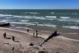 People walk a beach along Lake Michigan in Whiting, Ind. Credit: Scott Olson/Getty Images
