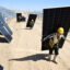 Workers carry solar panels to be installed at a one-million-kilowatt photovoltaic project in Lingwu, China, on April 14. Credit: STR/AFP via Getty Images