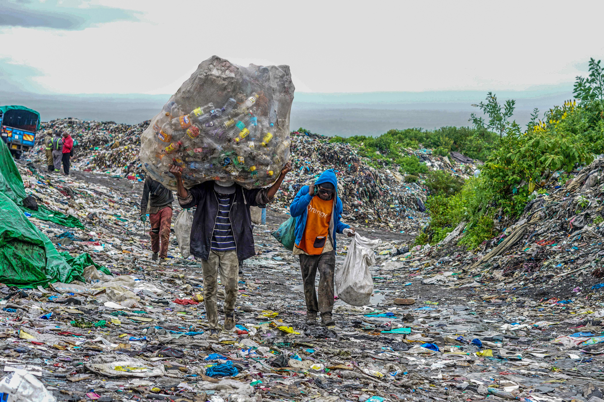 Waste pickers carry plastic materials to recycle at the Gioto dumping site in Nakuru, Kenya. Credit: James Wakibia/SOPA Images/LightRocket via Getty Images