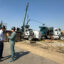 Bedrock Energy CTO Silviu Livescu (right) and Sen. John Hickenlooper (D-Colo.) talk in front of a drill rig on Wednesday at the Northwest Colorado Business District in Hayden, Colo. Credit: Emily Goldfield