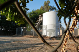 Hydrocarbon storage tanks—like this one in the backyard of a home in Arvin, Calif., and next to a playground—pose a disproportionate health risk when they leak. In addition to the climate super-pollutant methane, they emit a cocktail of toxic gases, including the carcinogen benzene. Credit: Liza Gross/Inside Climate News